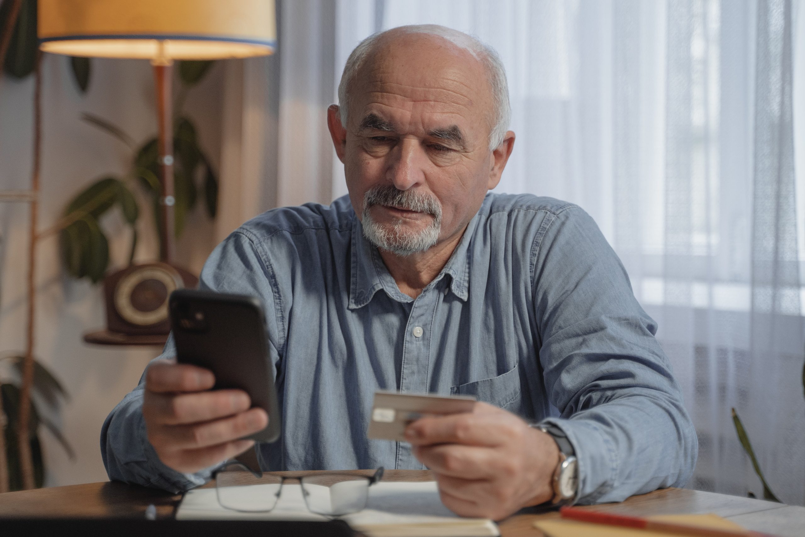 Home Equity Line Of Credit - HELOC - man sitting at table looking at phone