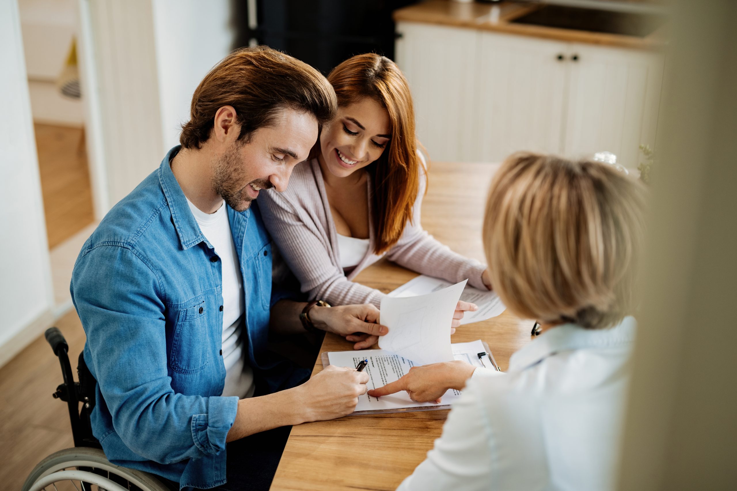 Young man in wheel chair meeting with financial advisor during insurance review