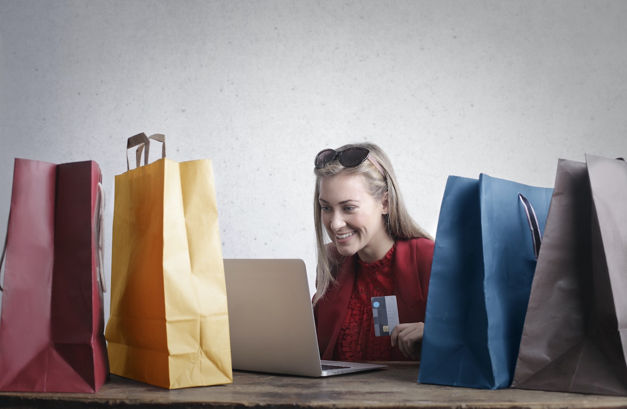 girl in front of computer buying lot of stuff with credit card