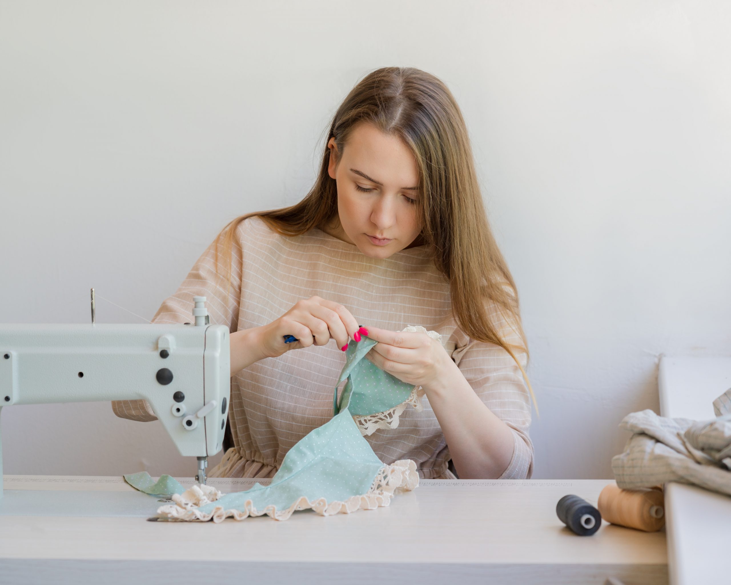 female sewing to sell her work as a side hustle