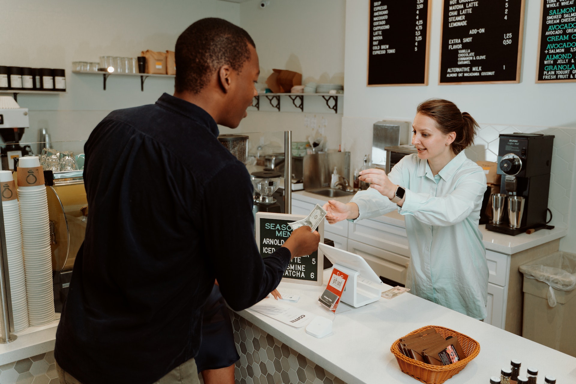 Pay Off Credit Card Debt/Man at coffee shop paying with cash at the register - paying off your debt